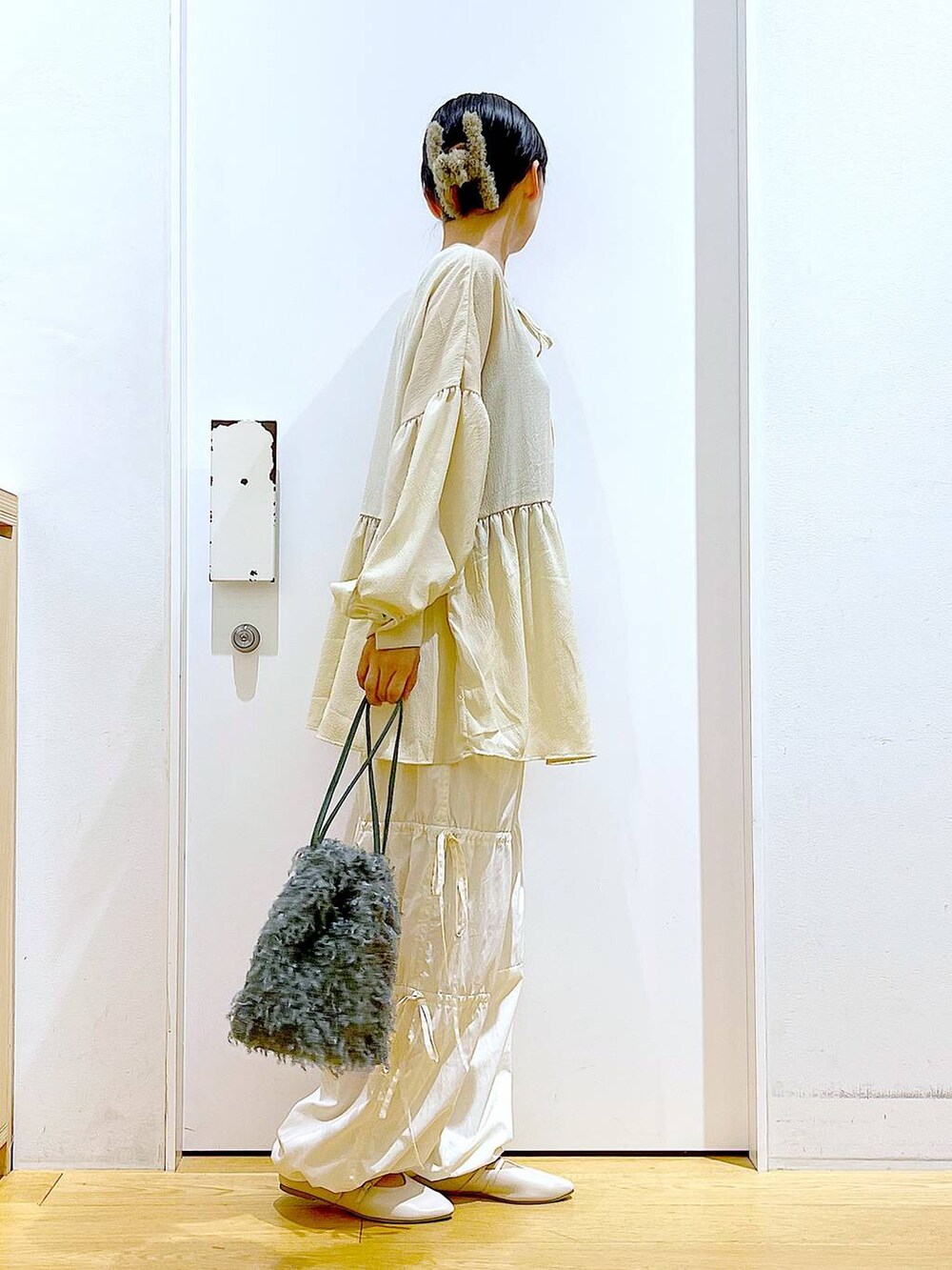 グリーン系のショルダーバッグ、ホワイト系のパンプス、ホワイト系のその他パンツを着用したレディースの秋コーディネートの4枚目の写真