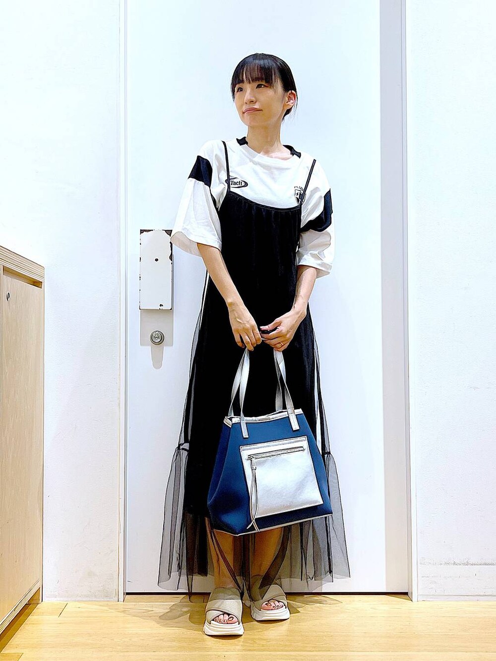 ベージュ系のサンダル、ブルー系のトートバッグ、ホワイト系のTシャツ/カットソーを着用したレディースの夏コーディネートの2枚目の写真