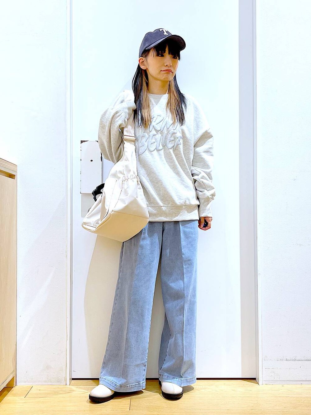 ブルー系のデニムパンツ、ベージュ系のスウェット、ベージュ系のブーツを着用したレディースの冬コーディネートの2枚目の写真