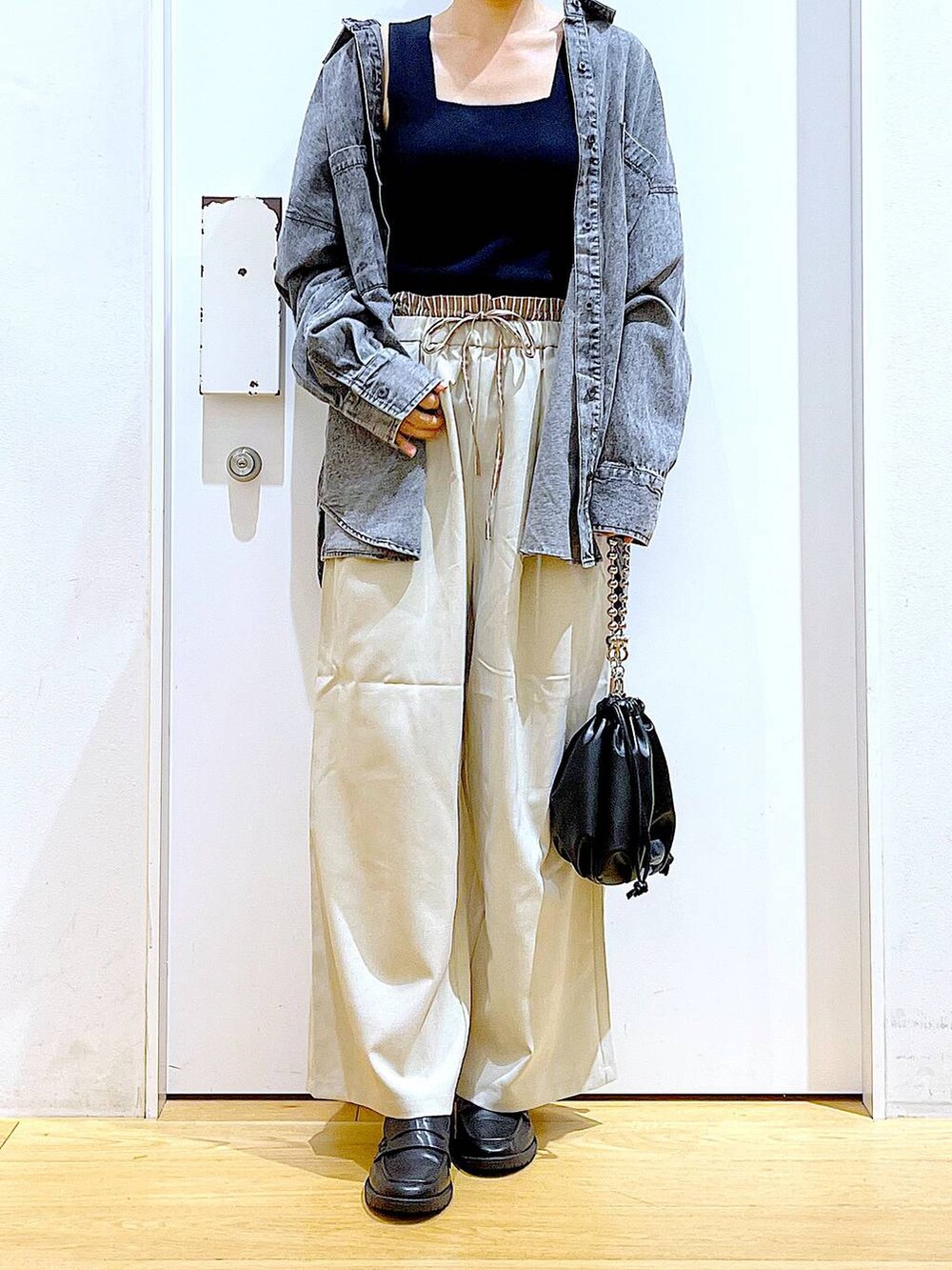 ブラック系のショルダーバッグ、ブラック系のローファー、ブラック系のニット/セーターを着用したレディースの秋コーディネートの6枚目の写真