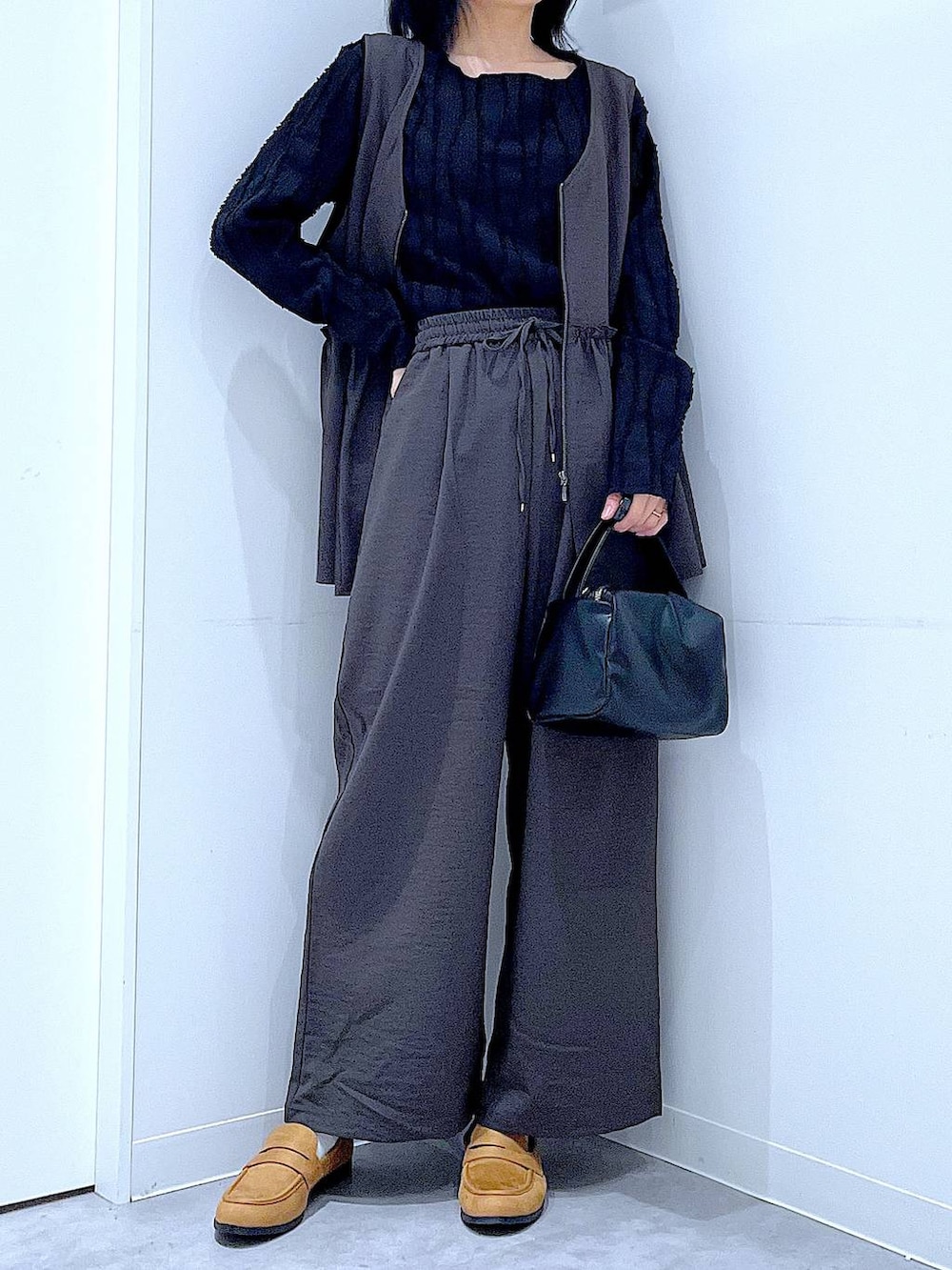 グレー系のその他パンツ、ブラック系のTシャツ/カットソー、ブラック系のショルダーバッグを着用したレディースの春コーディネートの6枚目の写真