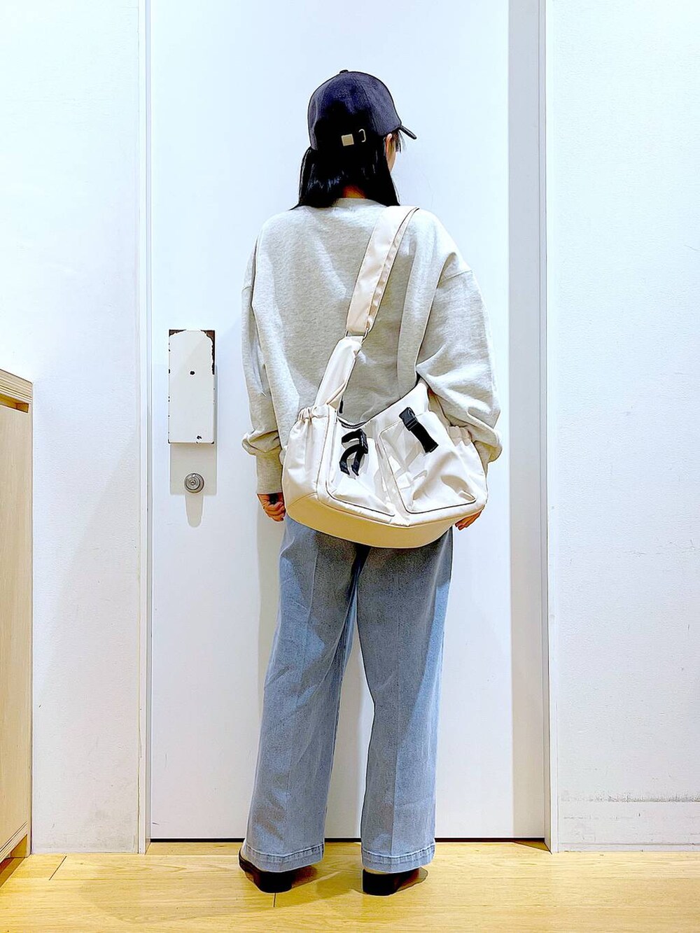 ブルー系のデニムパンツ、ベージュ系のスウェット、ベージュ系のブーツを着用したレディースの冬コーディネートの5枚目の写真