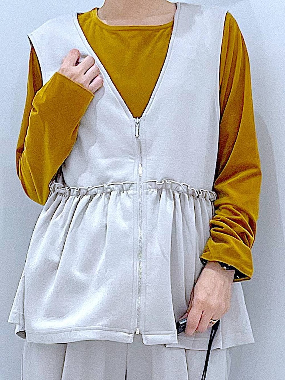 ブラウン系のボストンバッグ、グレー系のベスト、グレー系のその他パンツを着用したレディースの秋コーディネートの7枚目の写真