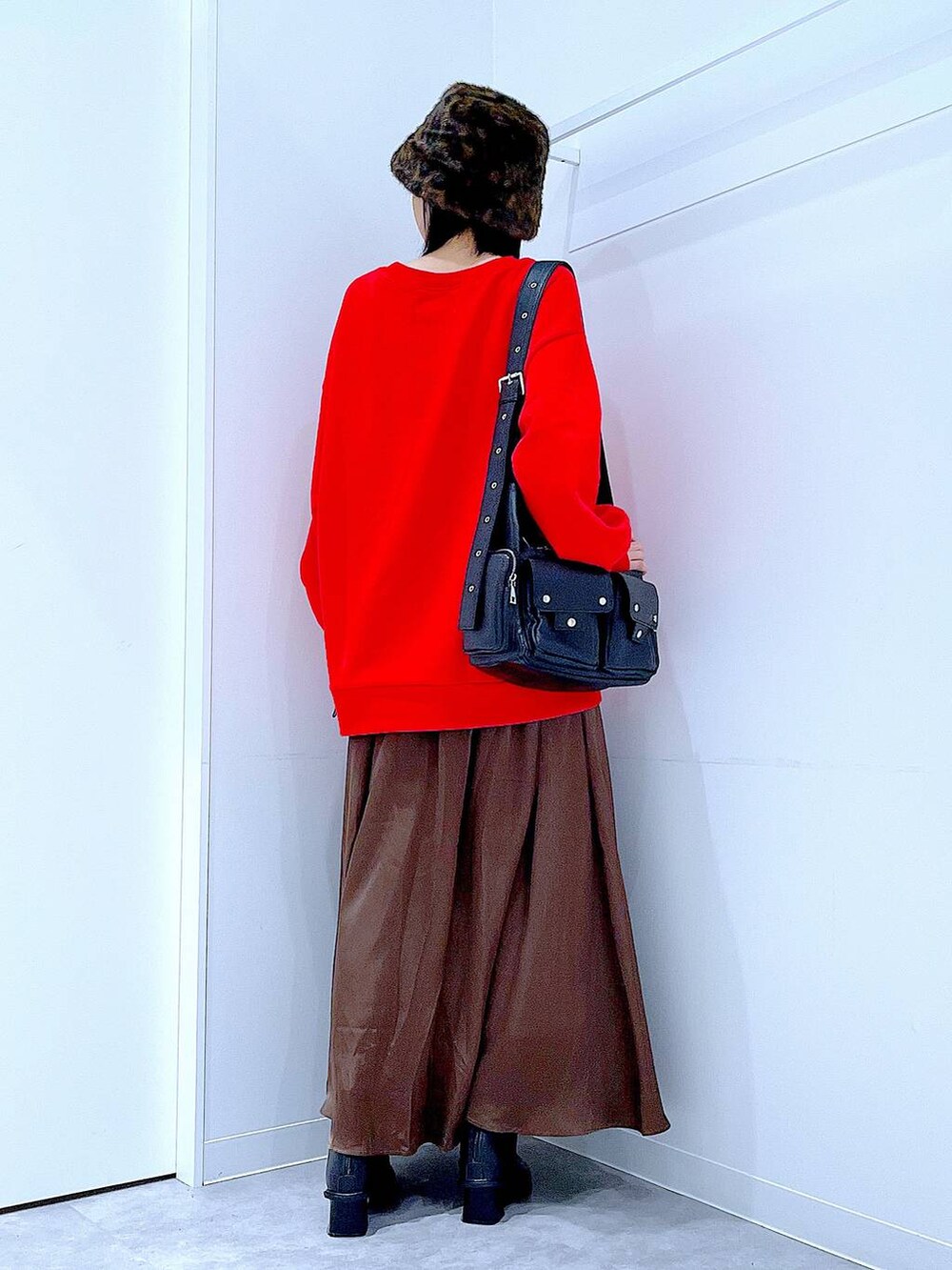 ブラック系のショルダーバッグ、ブラック系のブーツ、レッド系のスウェットを着用したレディースの秋コーディネートの5枚目の写真