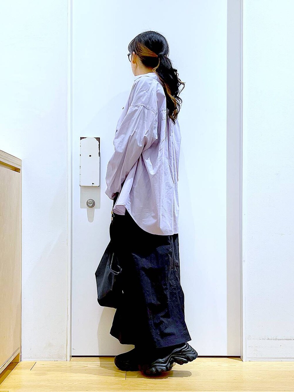 ブルー系のシャツ/ブラウス、ブラック系のスニーカー、ブラック系のショルダーバッグを着用したレディースの春コーディネートの3枚目の写真