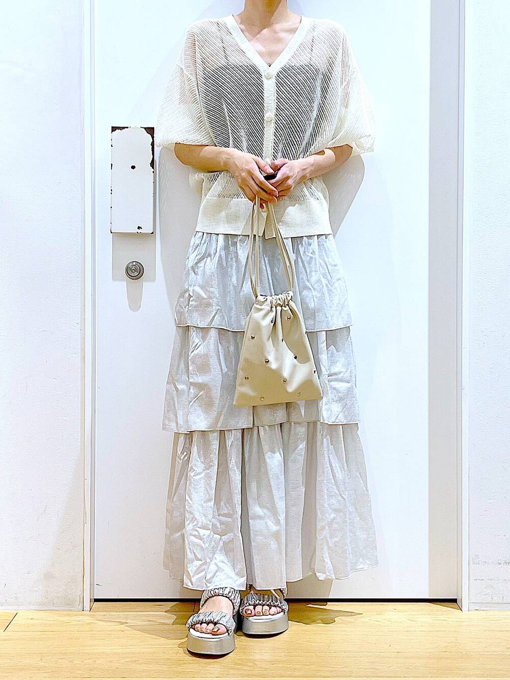 シルバー系のサンダル、ホワイト系のショルダーバッグ、シルバー系のスカートを着用したレディースの夏コーディネートの6枚目の写真