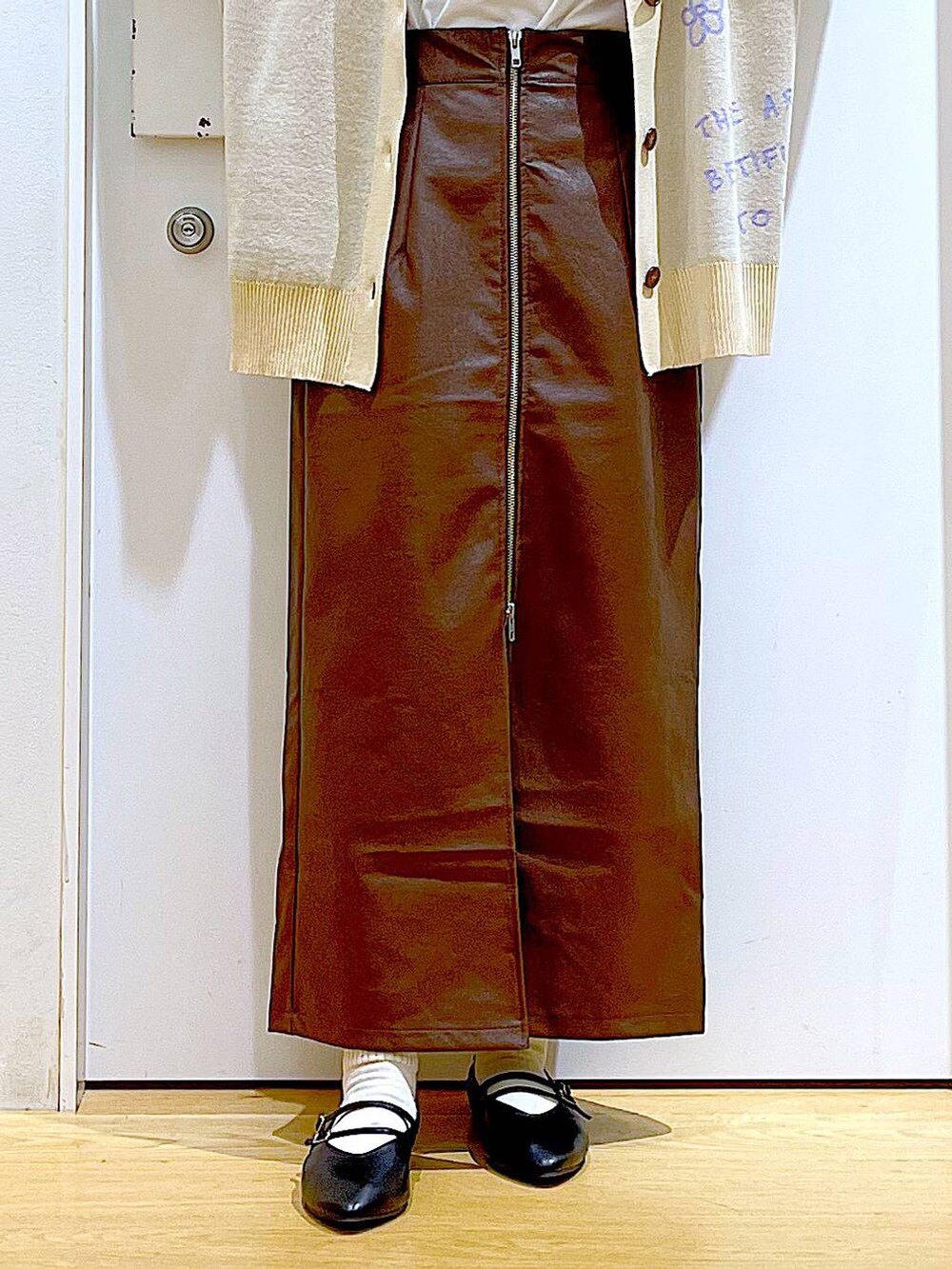 ブラウン系のスカート、ブラック系のショルダーバッグ、ブラック系のパンプスを着用したレディースの秋コーディネートの8枚目の写真