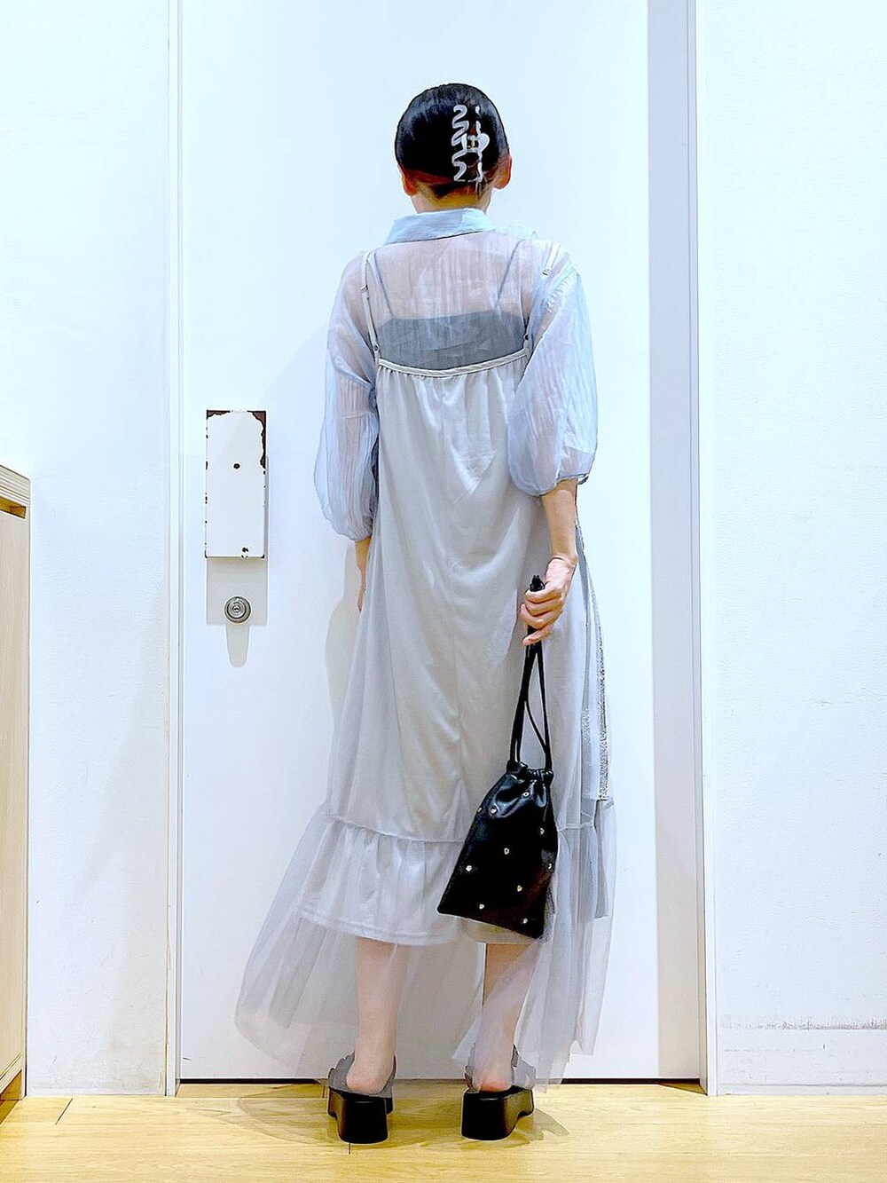 ブラック系のサンダル、ブラック系のショルダーバッグ、ブルー系のシャツ/ブラウスを着用したレディースの夏コーディネートの5枚目の写真