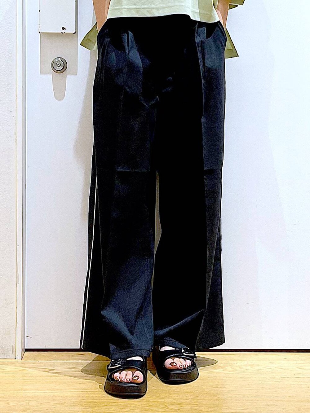 ブラック系のサンダル、ブラック系のショルダーバッグ、ブラック系のスラックスを着用したレディースの夏コーディネートの8枚目の写真