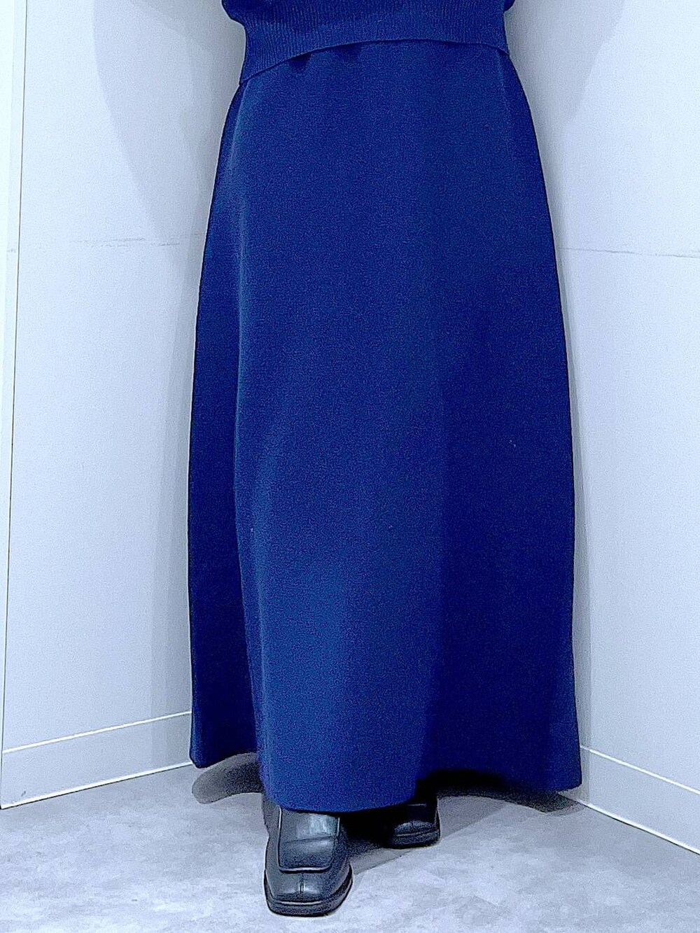 ブラック系のブーツ、ホワイト系のショルダーバッグ、ブルー系のスカートを着用したレディースの冬コーディネートの8枚目の写真