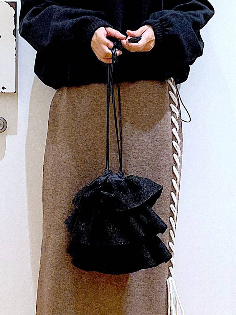 ブラック系のブーツ、ブラウン系のスカート、ブラック系のスウェットを着用したレディースの冬コーディネートの9枚目の写真