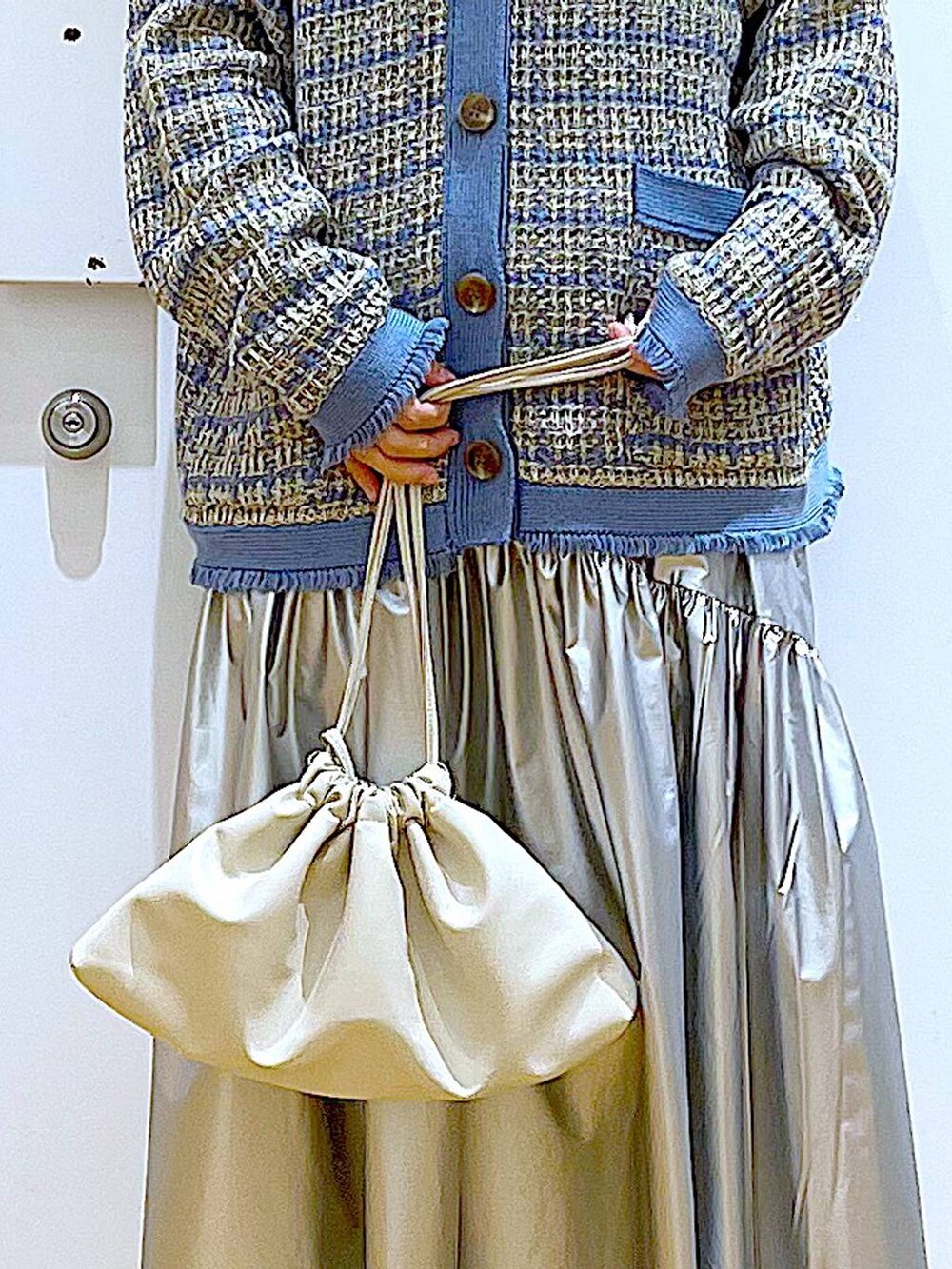 ブラック系のTシャツ/カットソー、シルバー系のスカート、ブルー系のカーディガン/ボレロを着用したレディースの冬コーディネートの9枚目の写真