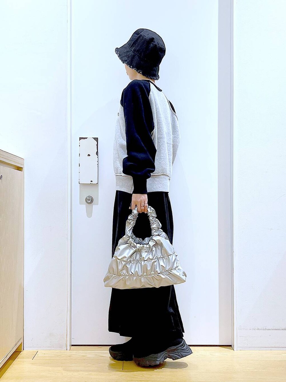 ブラック系のブーツ、シルバー系のショルダーバッグ、ブラック系のニット/セーターを着用したレディースの冬コーディネートの3枚目の写真