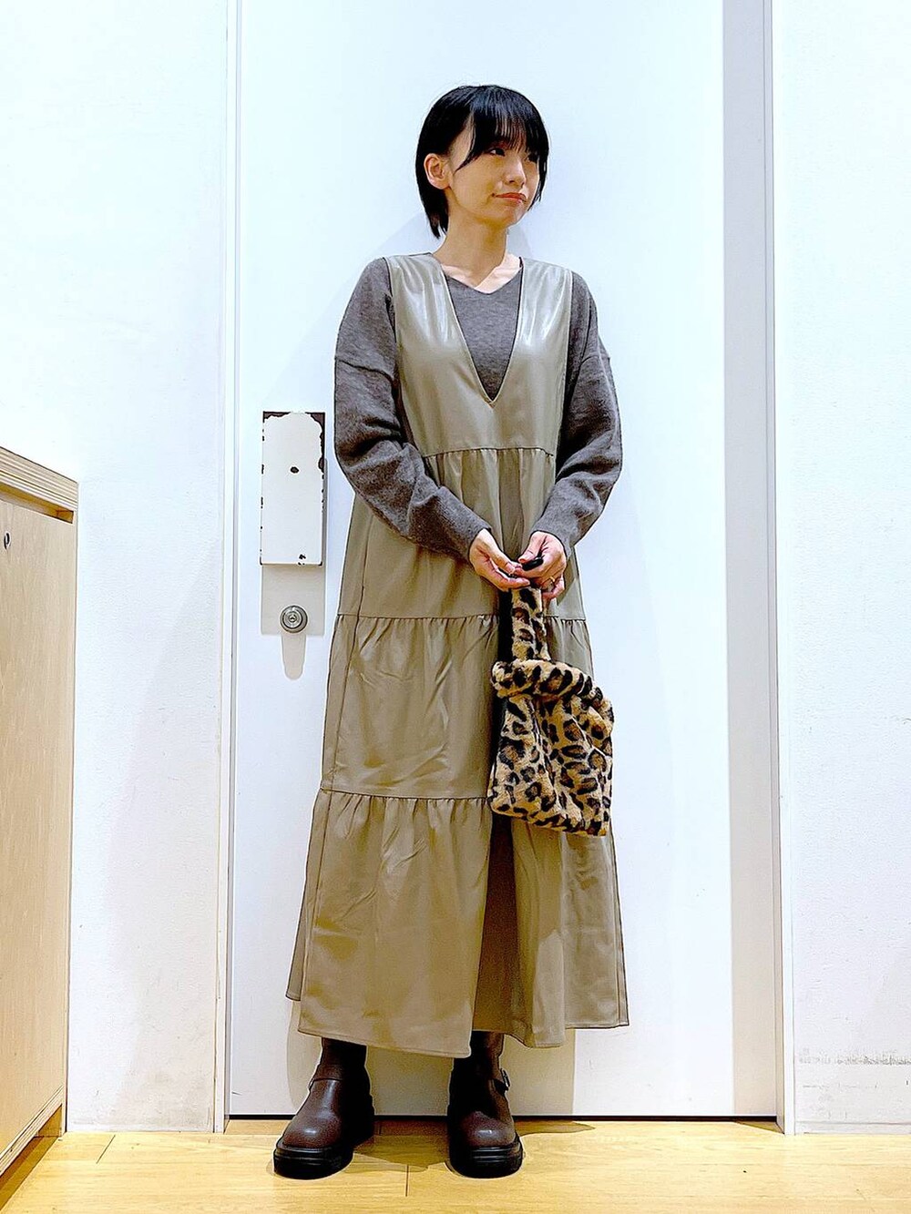 ブラウン系のニット/セーター、その他のショルダーバッグ、ブラウン系のブーツを着用したレディースの冬コーディネートの2枚目の写真