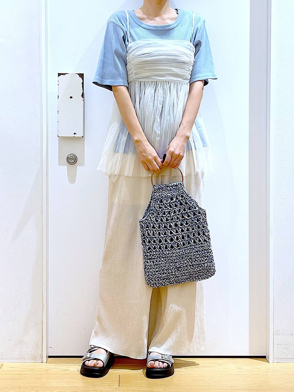 ホワイト系のキャミソール、シルバー系のサンダル、ブルー系のハンドバッグを着用したレディースの夏コーディネートの6枚目の写真