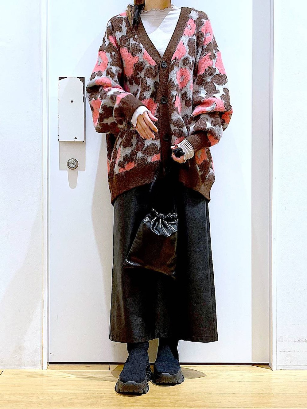 グレー系のTシャツ/カットソー、ブラック系のブーツ、ブラック系のスカートを着用したレディースの冬コーディネートの6枚目の写真