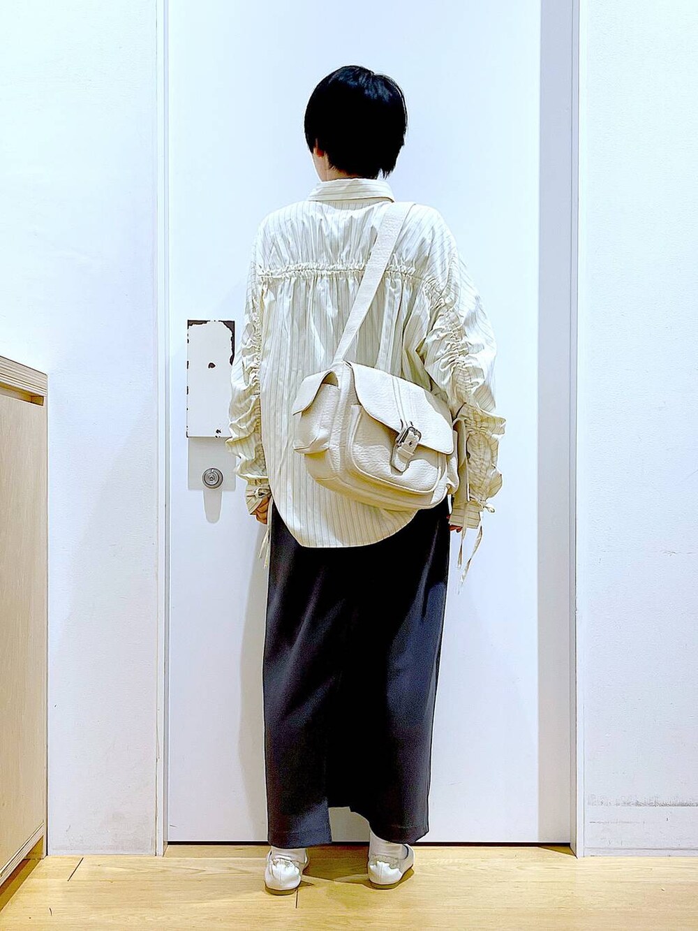 ホワイト系のパンプス、ベージュ系のシャツ/ブラウス、グレー系のスカートを着用したレディースの春コーディネートの5枚目の写真