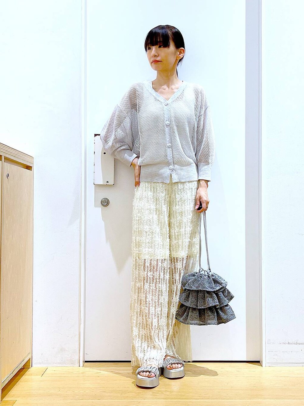 シルバー系のショルダーバッグ、ホワイト系のニット/セーター、ホワイト系のその他パンツを着用したレディースの夏コーディネートの2枚目の写真