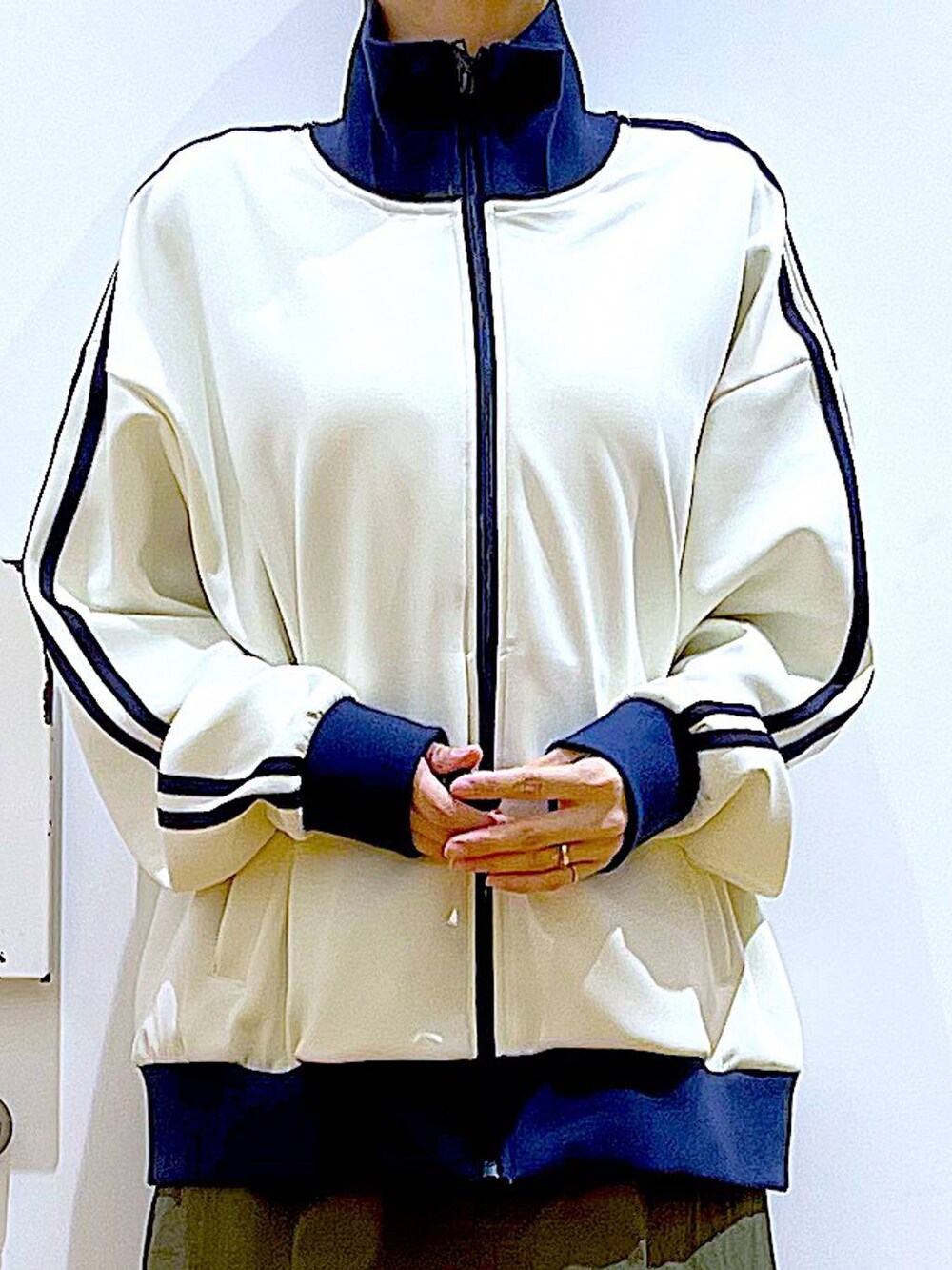 ホワイト系のトートバッグ、ブラック系のブーツ、グリーン系のスカートを着用したレディースの冬コーディネートの7枚目の写真