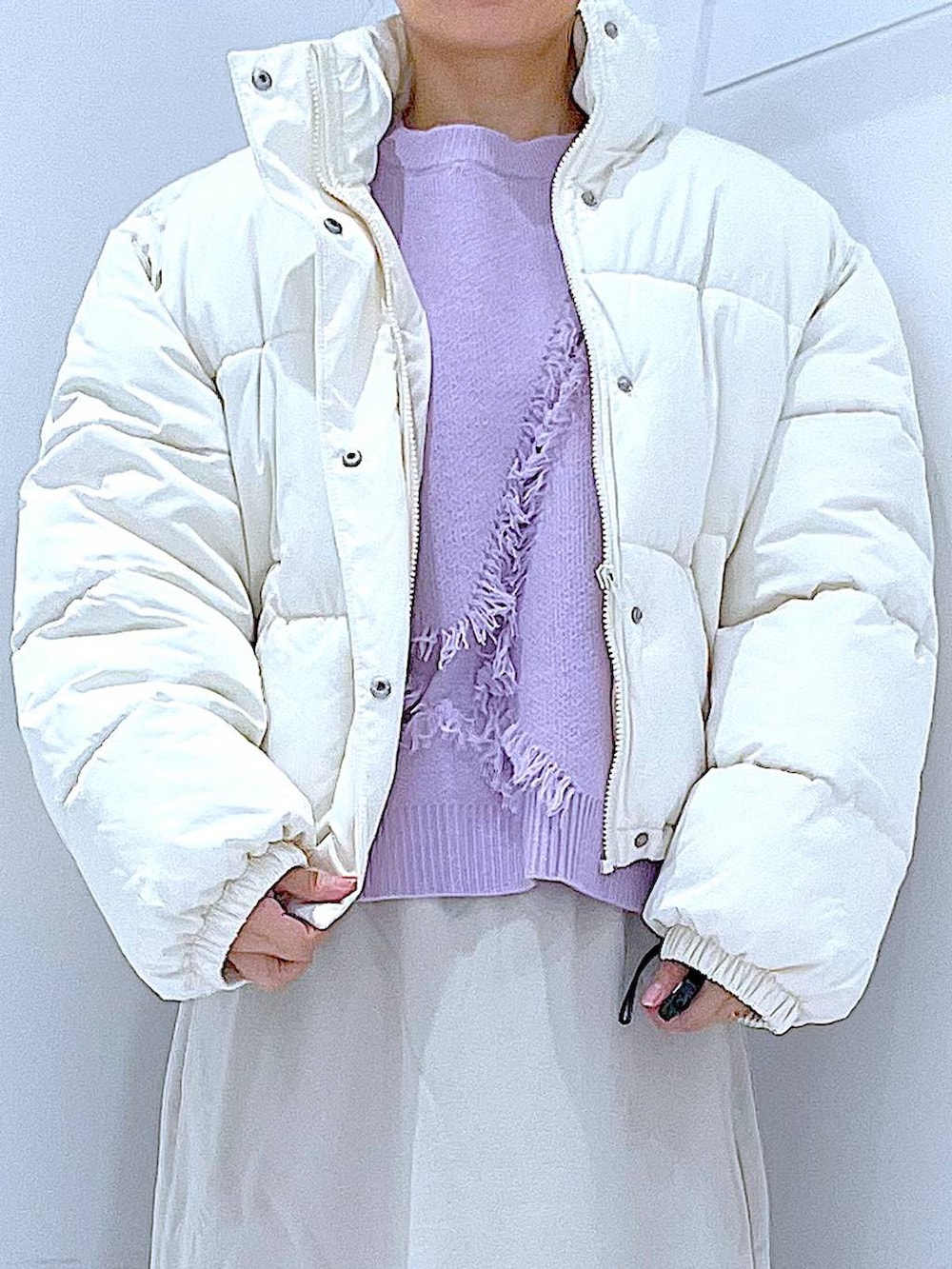 ホワイト系のブルゾン、ベージュ系のスカート、ブラック系のブーツを着用したレディースの冬コーディネートの7枚目の写真