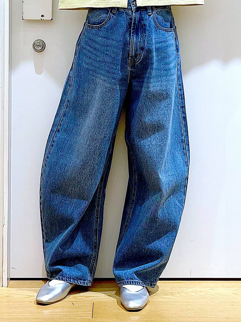 シルバー系のトートバッグ、ブルー系のデニムパンツ、シルバー系のパンプスを着用したレディースの春コーディネートの8枚目の写真