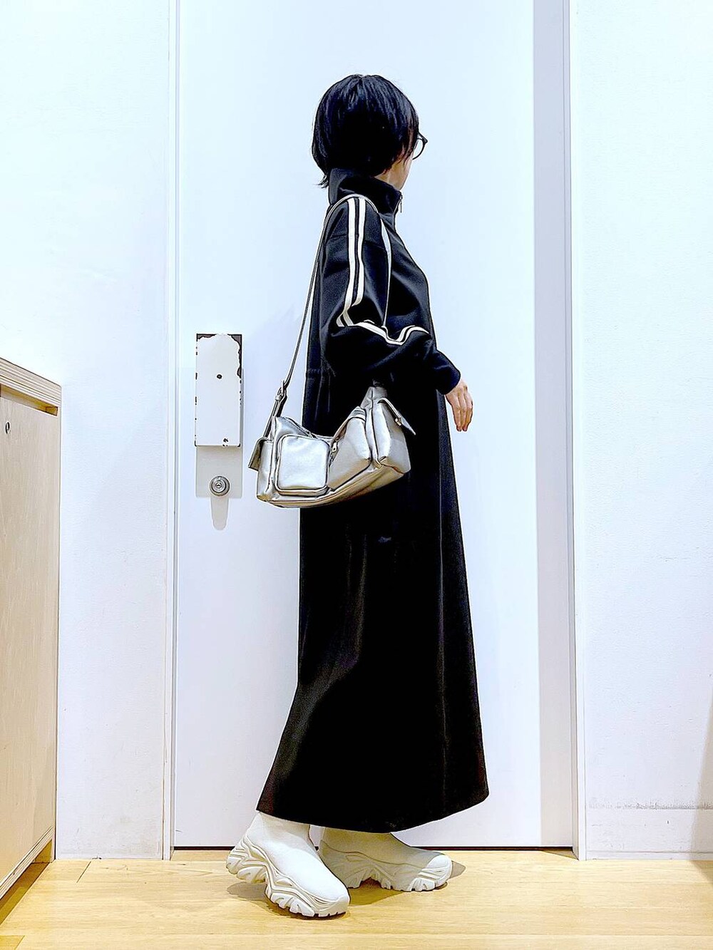 ベージュ系のブーツ、ブラック系のワンピース、その他のショルダーバッグを着用したレディースの秋コーディネートの4枚目の写真