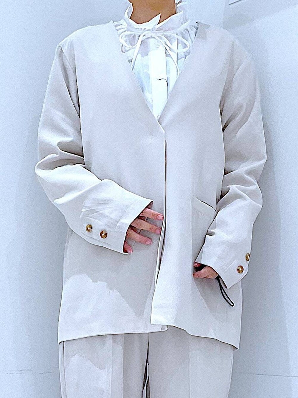 ブラック系のブーツ、ホワイト系のトートバッグ、ベージュ系のノーカラージャケットを着用したレディースの冬コーディネートの7枚目の写真