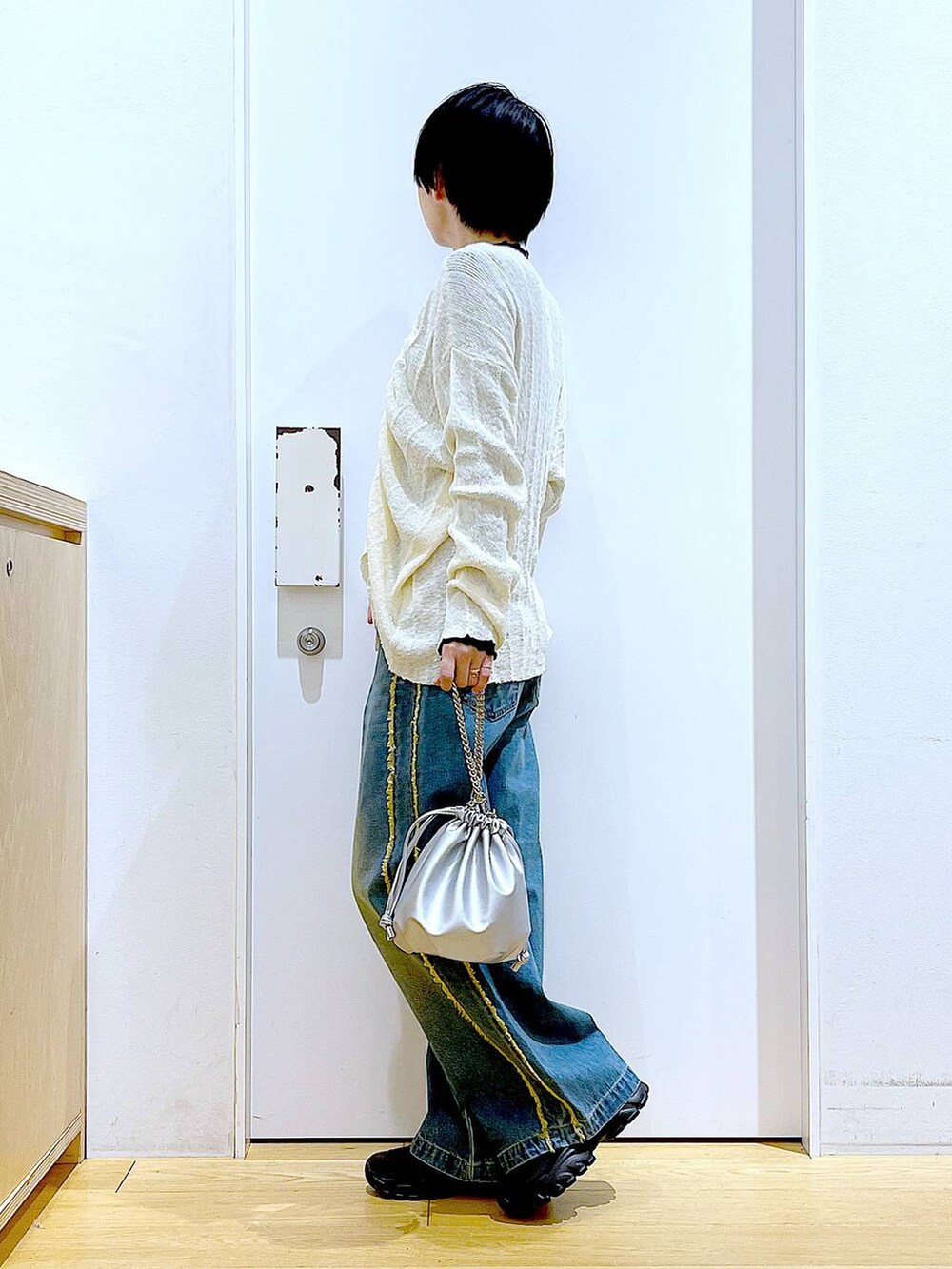 ブラック系のTシャツ/カットソー、シルバー系のショルダーバッグ、ブラック系のスニーカーを着用したレディースの春コーディネートの3枚目の写真