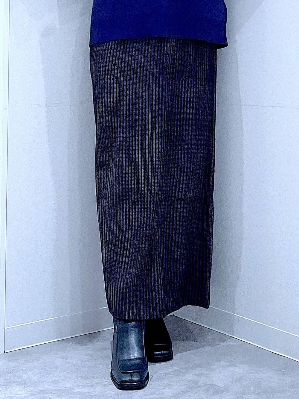 ブラック系のスカート、ブラック系のショルダーバッグ、ブラック系のブーツを着用したレディースの冬コーディネートの8枚目の写真