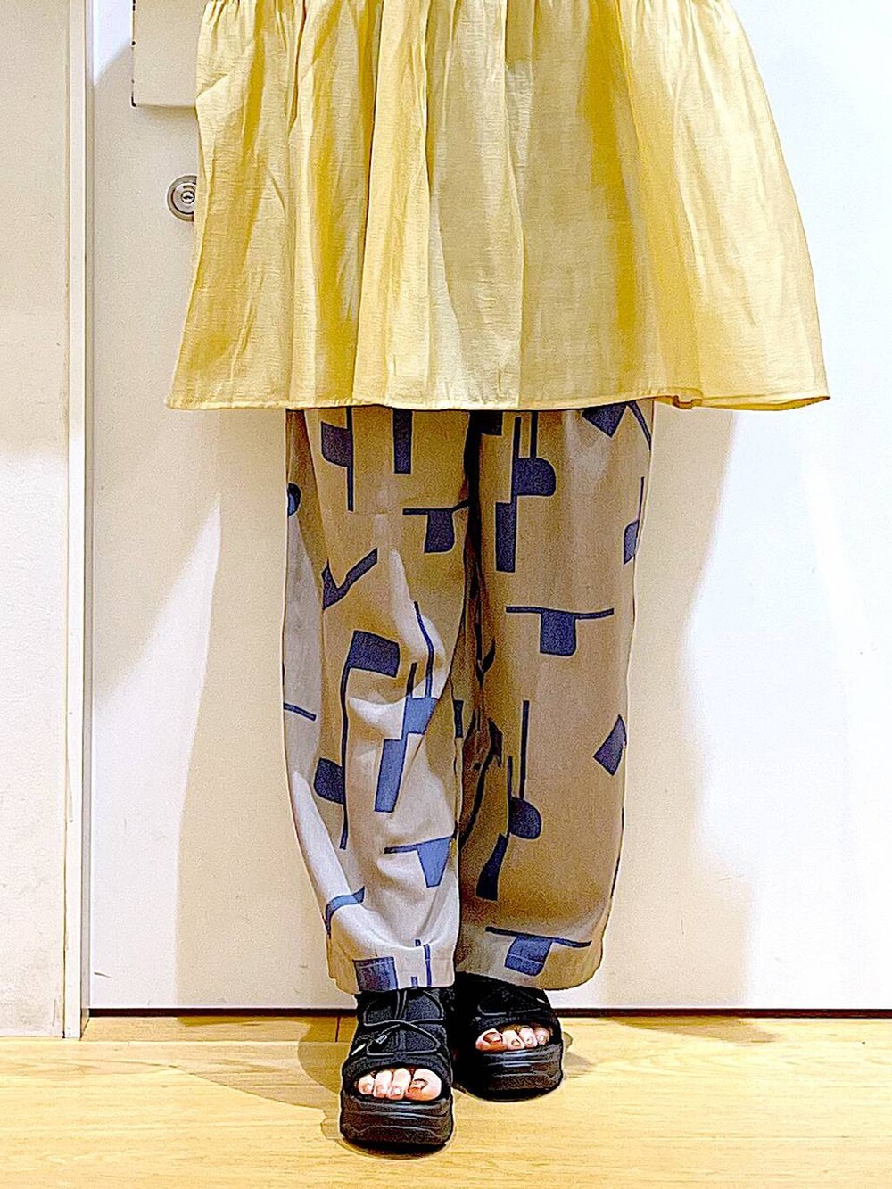 グレー系のその他パンツ、ホワイト系のショルダーバッグ、ブラック系のサンダルを着用したレディースの夏コーディネートの8枚目の写真