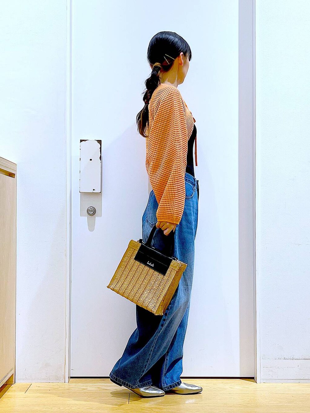 ブルー系のデニムパンツ、オレンジ系のカーディガン/ボレロ、その他のパンプスを着用したレディースの春コーディネートの4枚目の写真