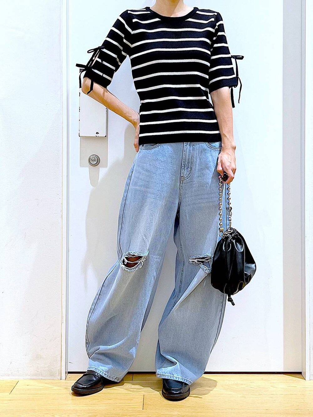 ブラック系のショルダーバッグ、ブラック系のローファー、ブラック系のニット/セーターを着用したレディースの秋コーディネートの6枚目の写真