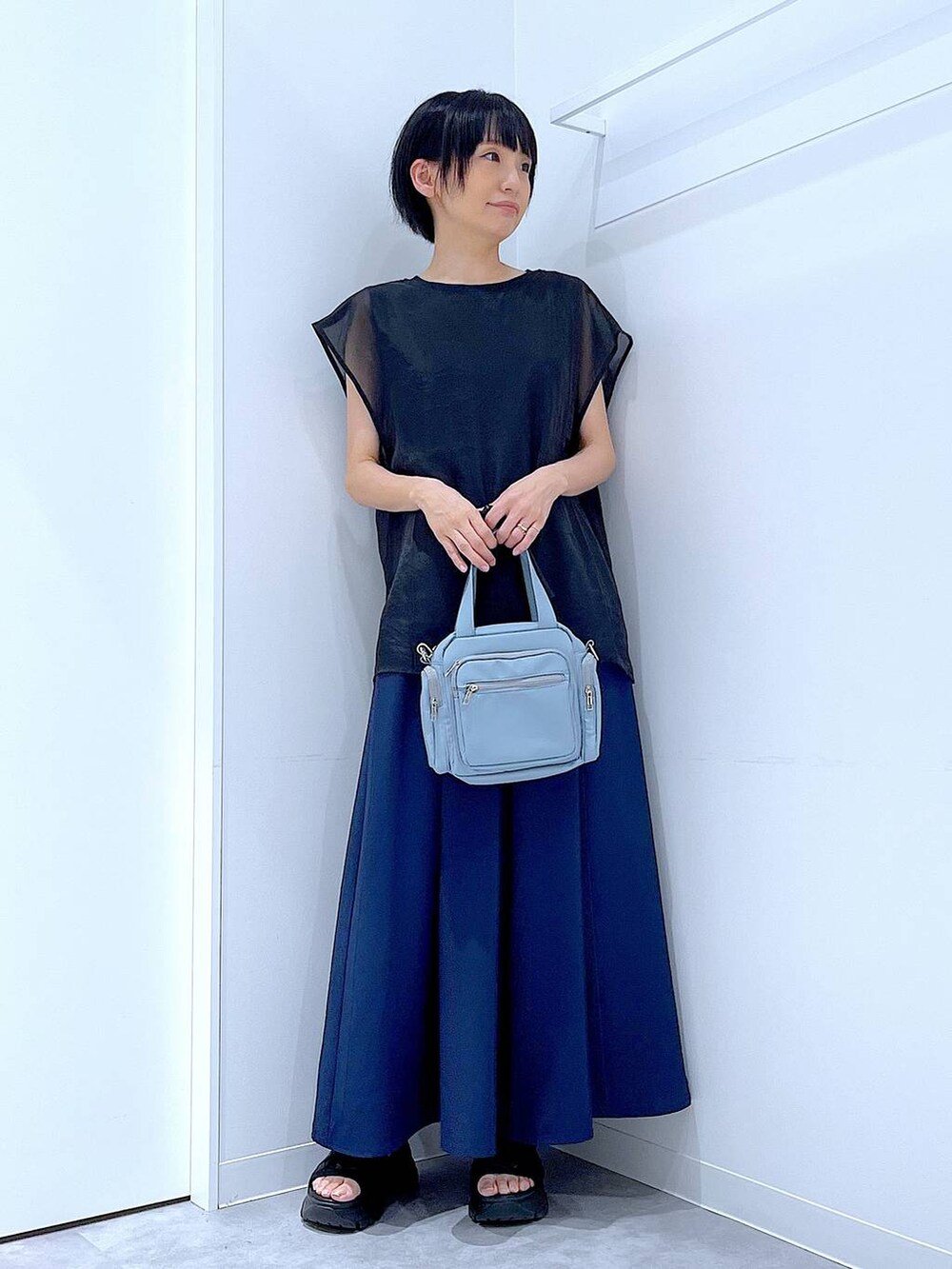 ブラック系のスニーカー、ブルー系のショルダーバッグ、ブルー系のその他パンツを着用したレディースの夏コーディネートの2枚目の写真