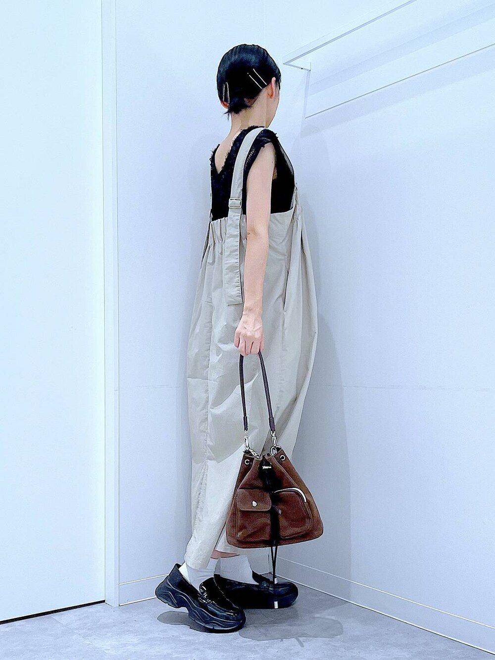 ブラック系のローファー、ブラウン系のショルダーバッグ、グレー系のワンピースを着用したレディースの秋コーディネートの4枚目の写真