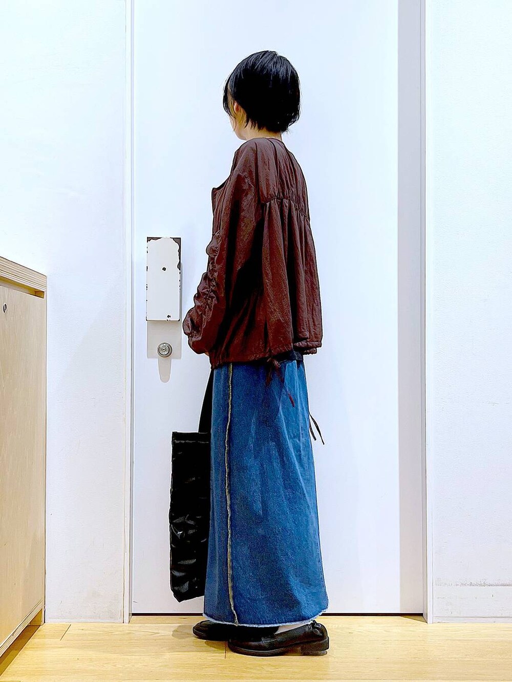 ブラック系のローファー、ブルー系のデニムスカート、ブラック系のTシャツ/カットソーを着用したレディースの秋コーディネートの3枚目の写真