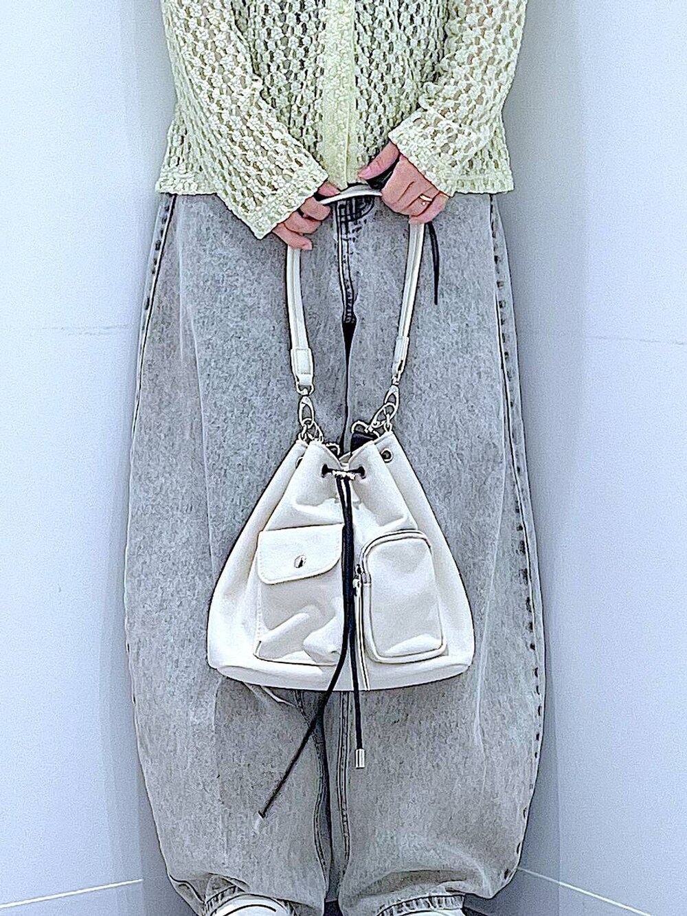 ベージュ系のデニムパンツ、ホワイト系のローファー、ホワイト系のショルダーバッグを着用したレディースの秋コーディネートの9枚目の写真