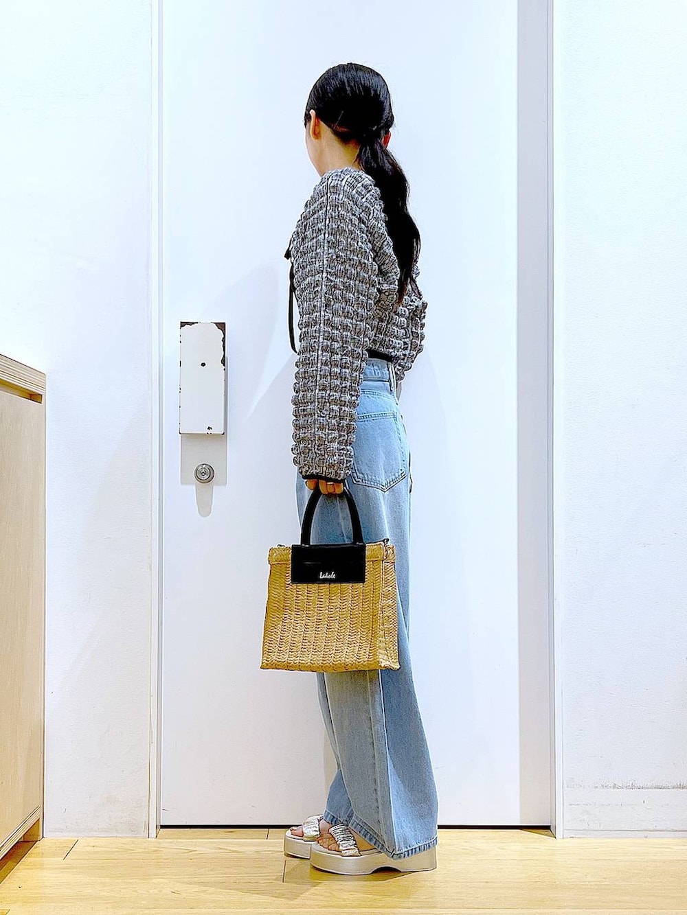 ブルー系のデニムパンツ、ブラック系のTシャツ/カットソー、ベージュ系のショルダーバッグを着用したレディースの夏コーディネートの3枚目の写真