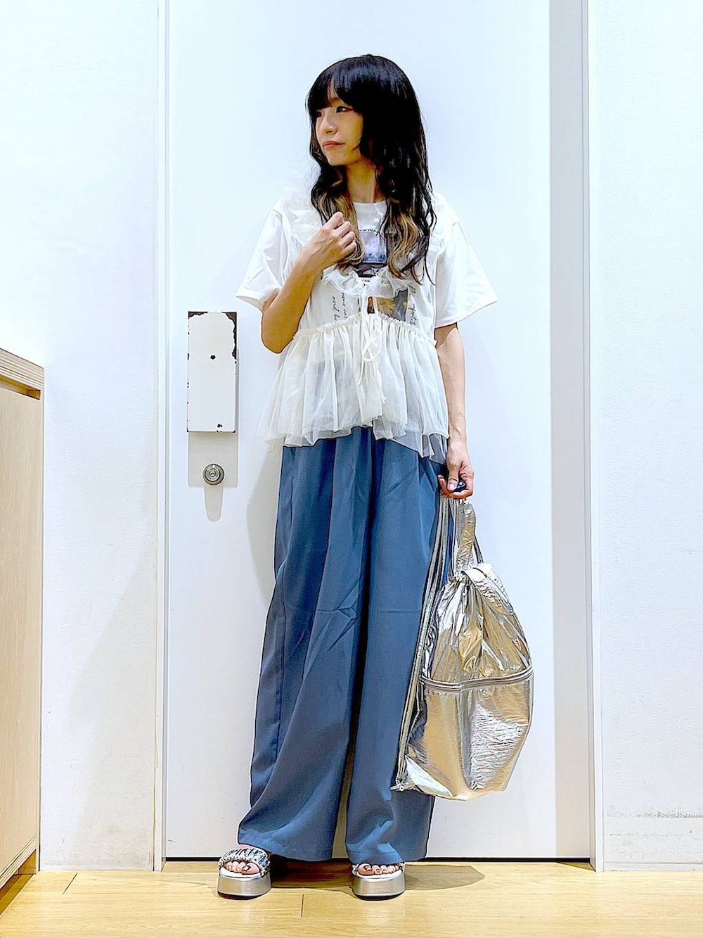 シルバー系のバックパック/リュック、ホワイト系のTシャツ/カットソー、シルバー系のサンダルを着用したレディースの夏コーディネートの2枚目の写真