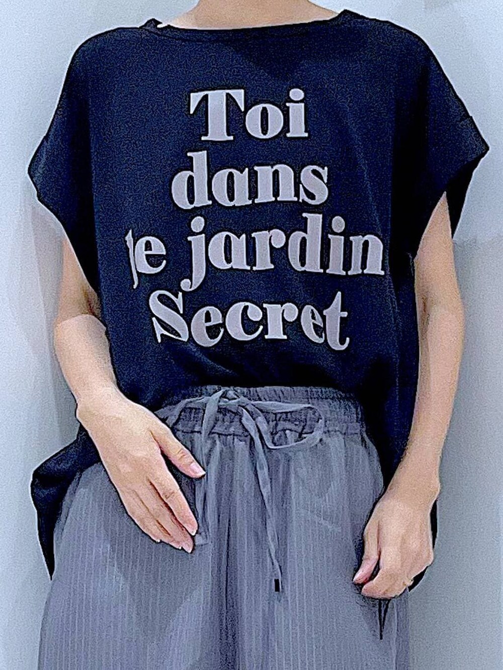 ブラック系のTシャツ/カットソー、グレー系のスラックス、ブラック系のハンドバッグを着用したレディースの秋コーディネートの7枚目の写真