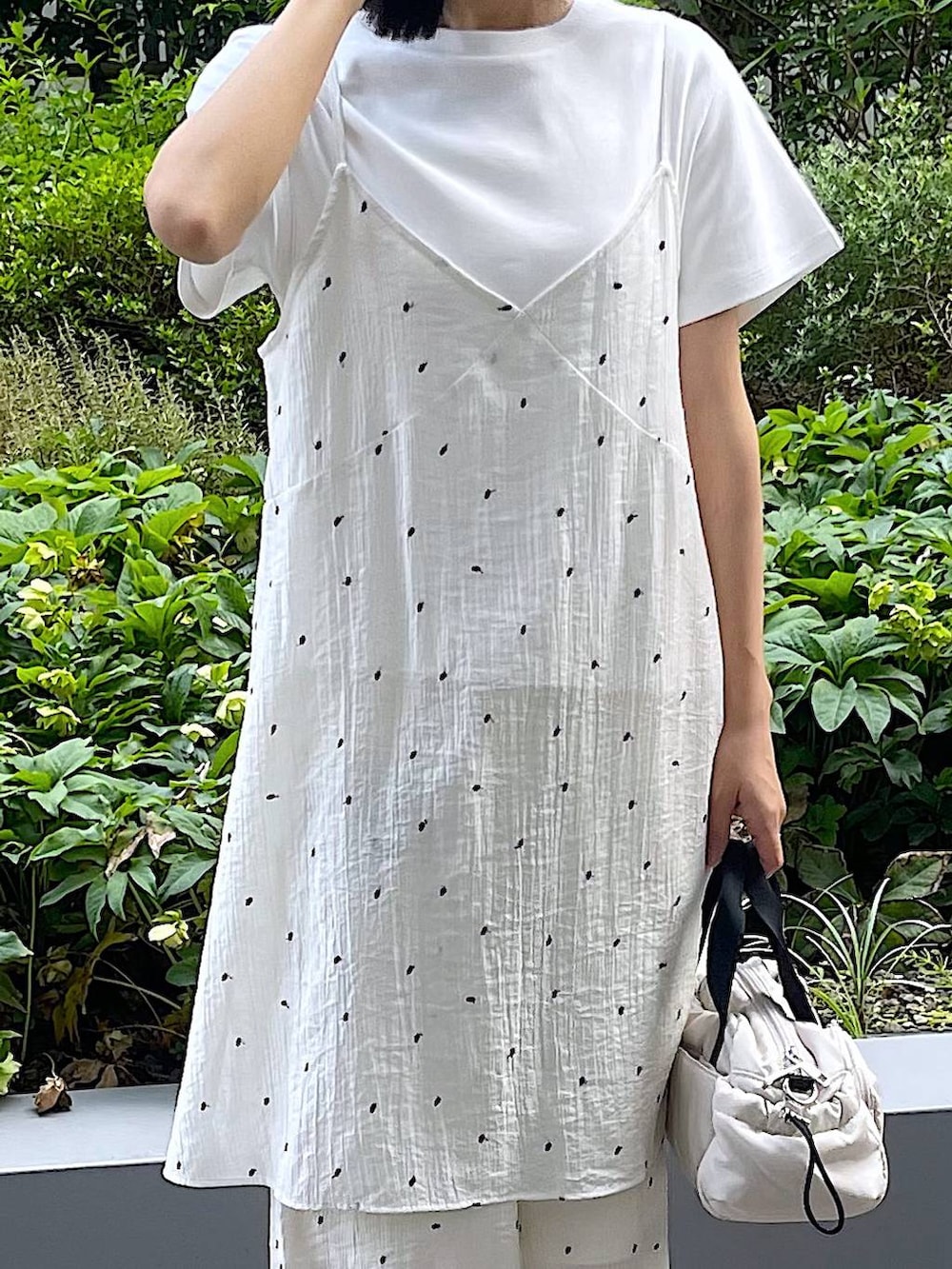 ホワイト系のサンダル、ホワイト系のTシャツ/カットソー、ホワイト系のショルダーバッグを着用したレディースの夏コーディネートの7枚目の写真