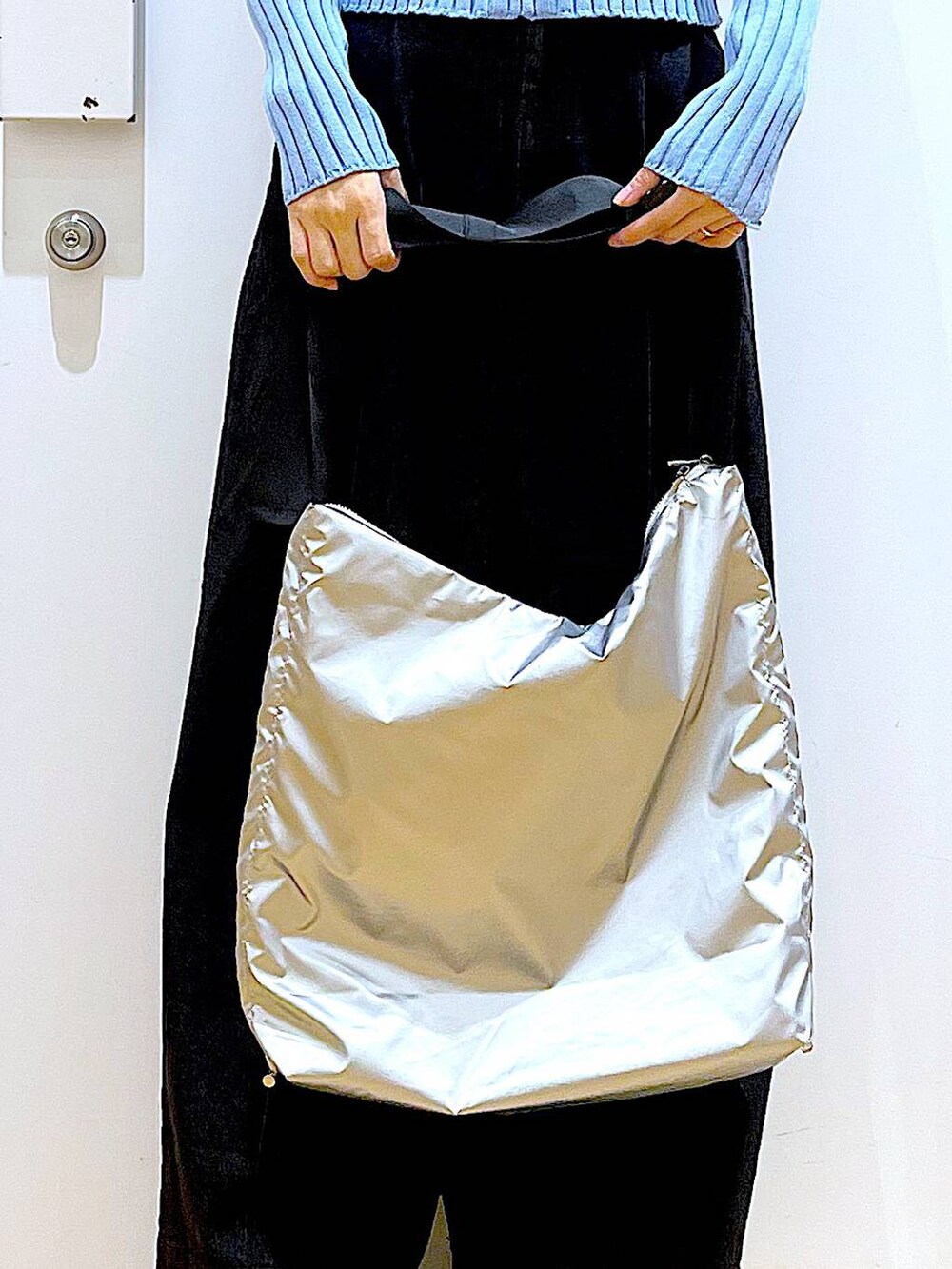 グレー系のデニムパンツ、ブルー系のカーディガン/ボレロ、ブラック系のブーツを着用したレディースの冬コーディネートの9枚目の写真