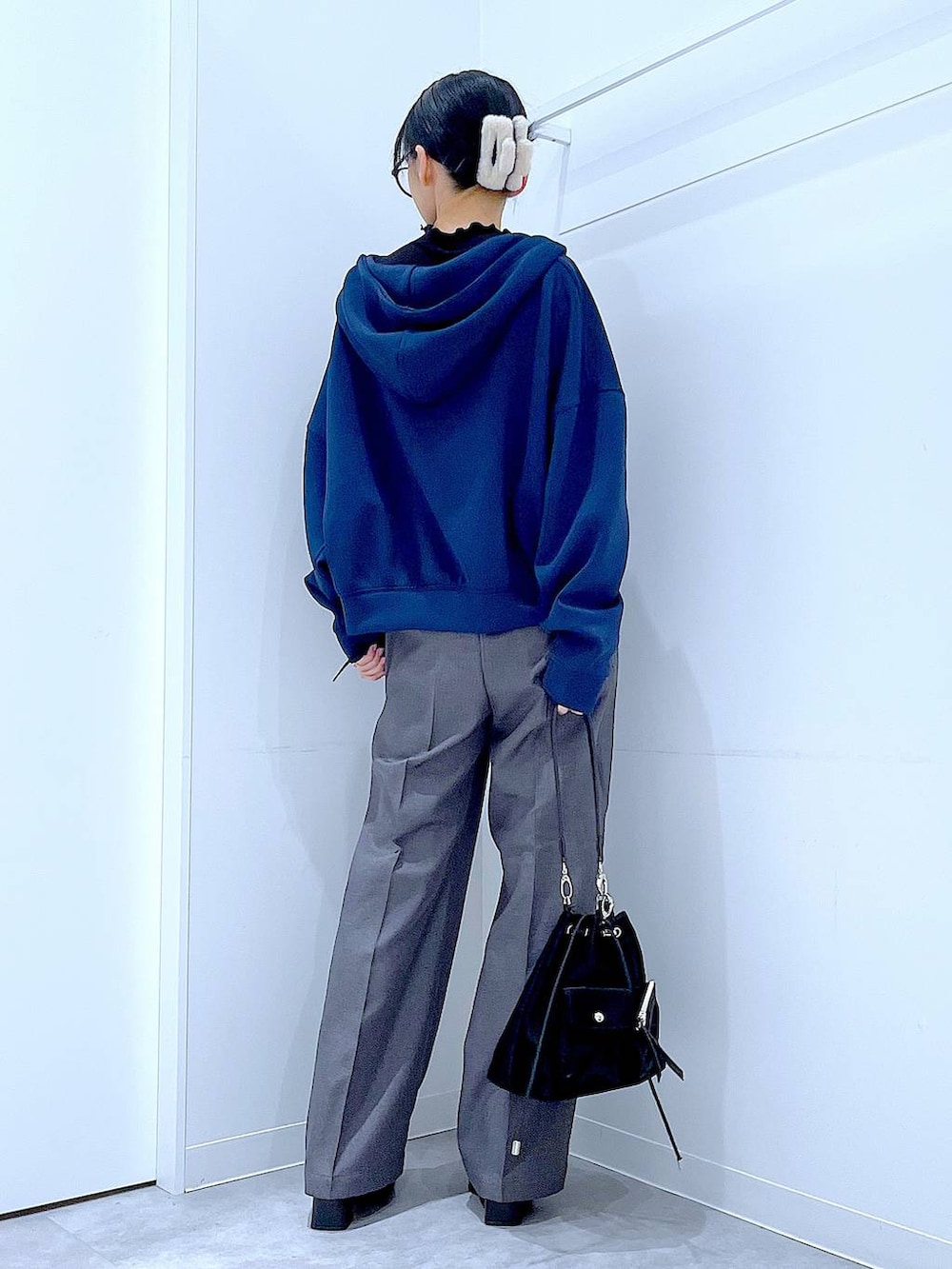 ブラック系のショルダーバッグ、ブラック系のブーツ、グレー系のスラックスを着用したレディースの冬コーディネートの5枚目の写真