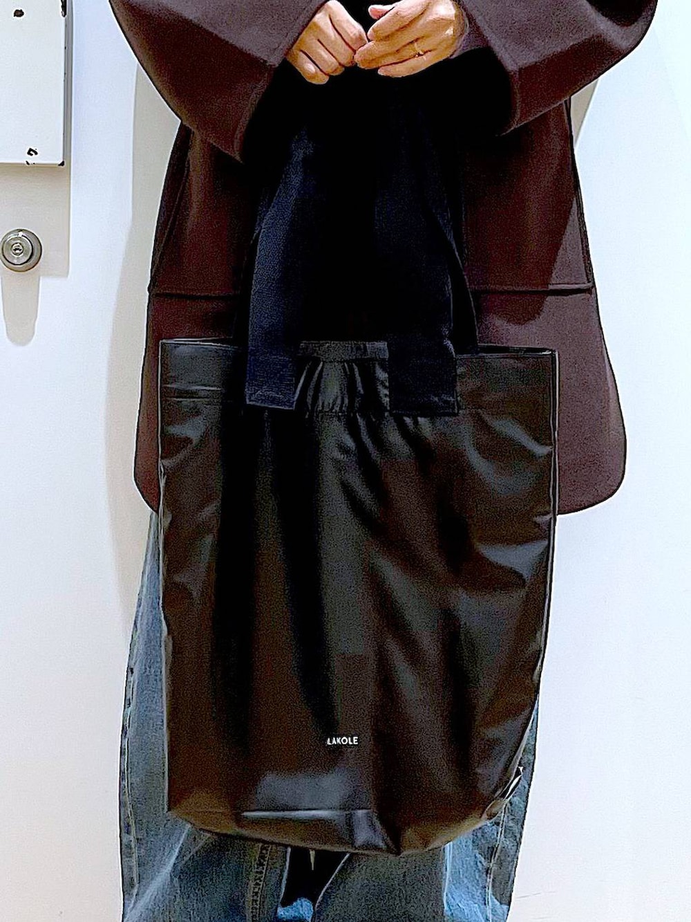 ブラウン系のその他アウター、ベージュ系のスニーカー、ブルー系のデニムパンツを着用したレディースの冬コーディネートの9枚目の写真