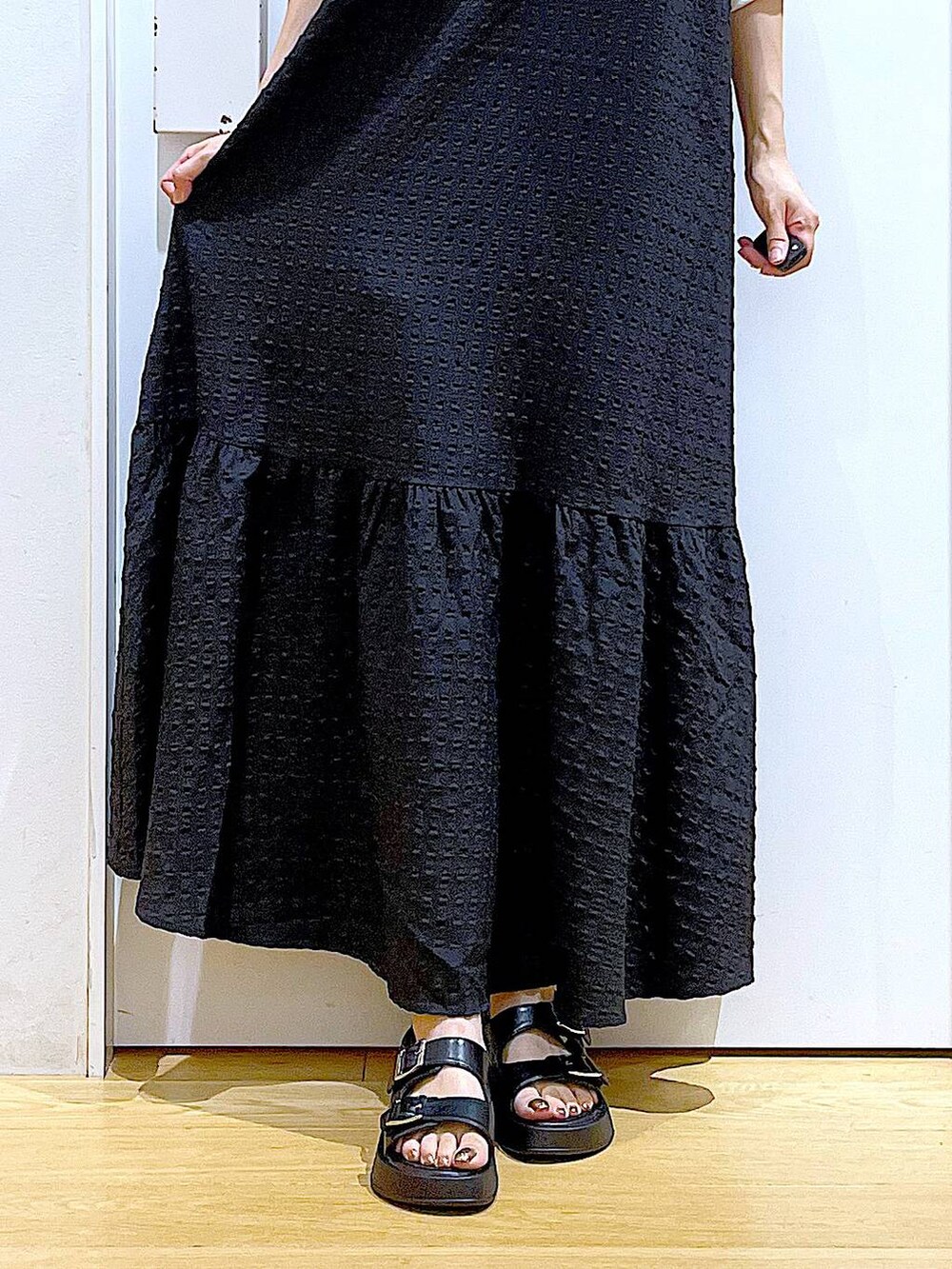 ブラック系のワンピース、ホワイト系のショルダーバッグ、ブラック系のサンダルを着用したレディースの夏コーディネートの8枚目の写真