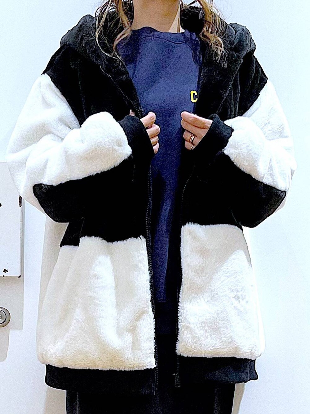 グレー系のスカート、ホワイト系のブルゾン、ブラック系のブーツを着用したレディースの冬コーディネートの7枚目の写真