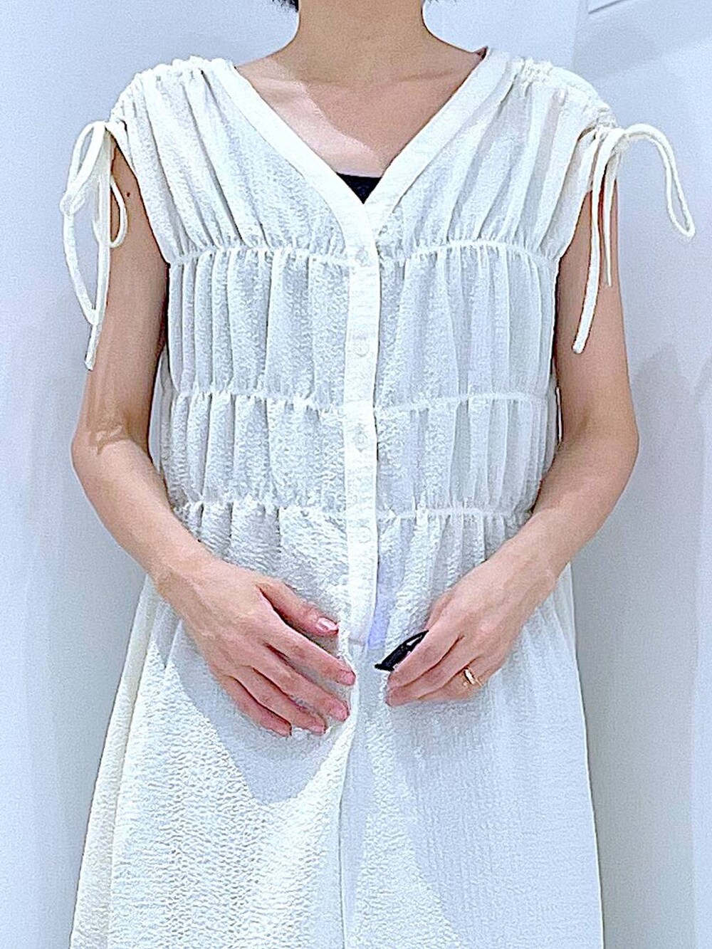 ブラック系のサンダル、ブルー系のデニムパンツ、ベージュ系のワンピースを着用したレディースの夏コーディネートの7枚目の写真