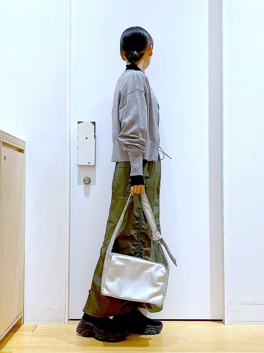 ブラック系のTシャツ/カットソー、グレー系のカーディガン/ボレロ、ブラック系のブーツを着用したレディースの冬コーディネートの4枚目の写真