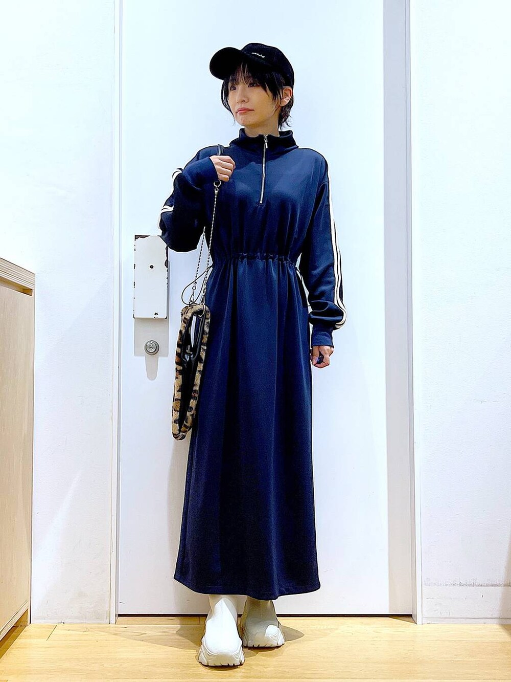 その他のショルダーバッグ、ベージュ系のブーツ、ブルー系のワンピースを着用したレディースの秋コーディネートの2枚目の写真