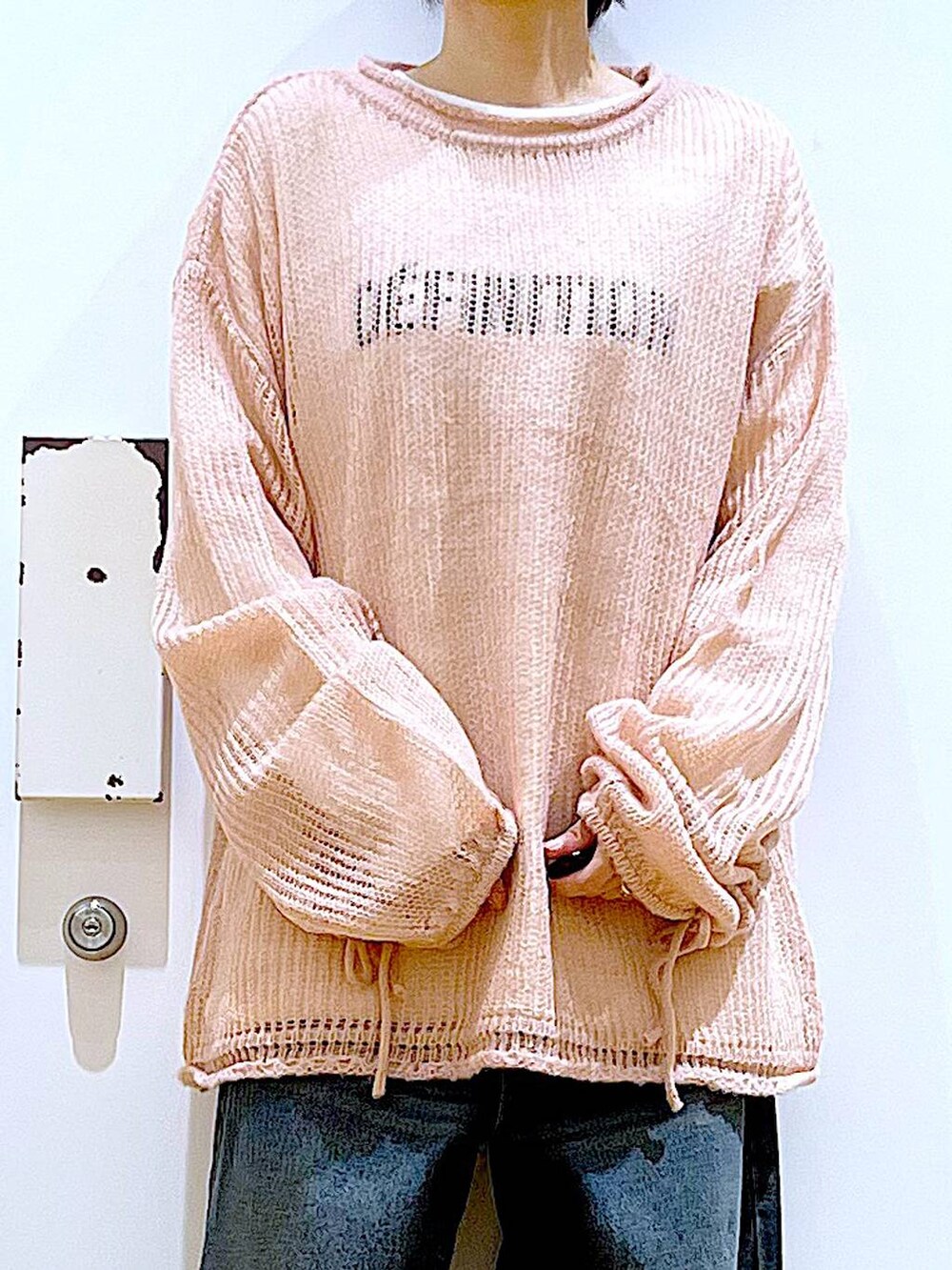 ブラック系のショルダーバッグ、ブラック系のブーツ、ピンク系のニット/セーターを着用したレディースの冬コーディネートの7枚目の写真