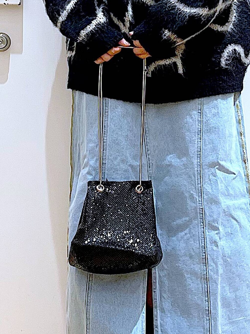 ブルー系のデニムスカート、ブラック系のブーツ、ブラック系のショルダーバッグを着用したレディースの冬コーディネートの9枚目の写真